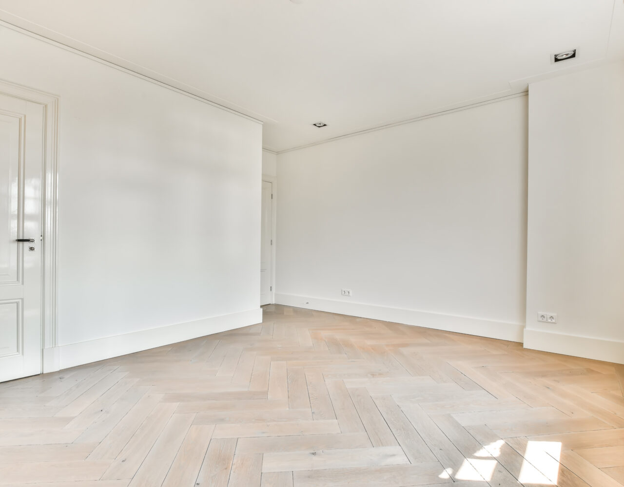 Empty hotel with white doors and white walls. Spacious living room with parquet floor